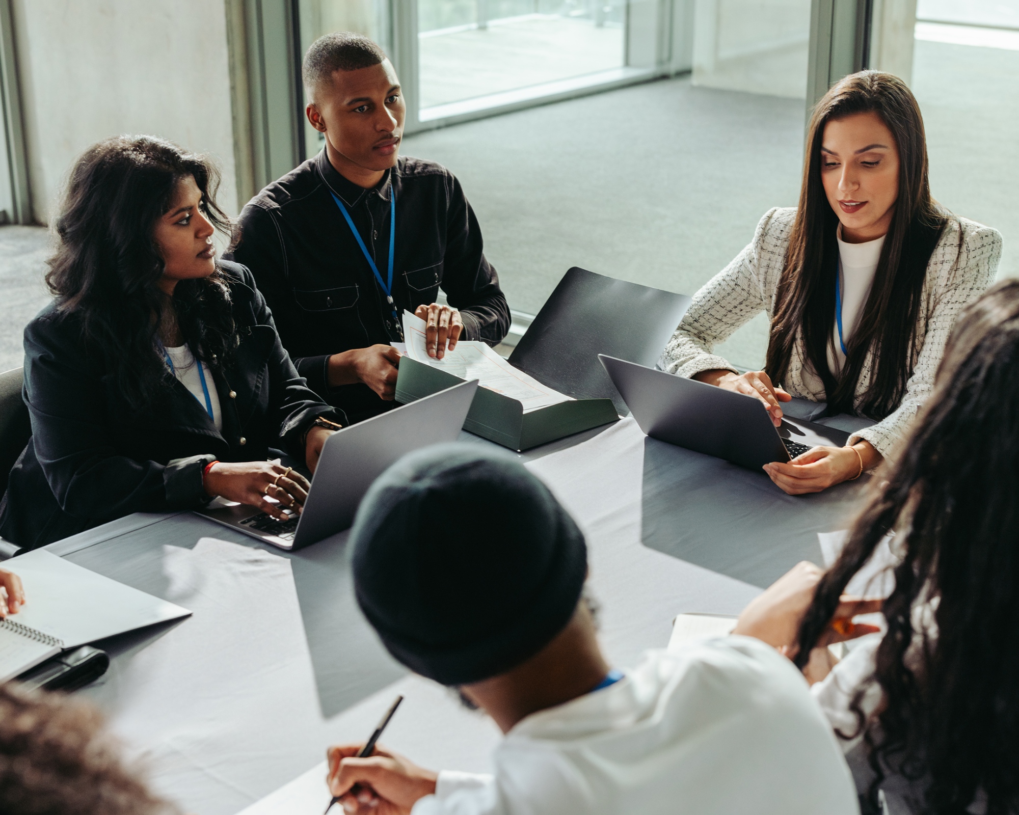 A group of cybersecurity professionals sit at a table to collaborate on a project.