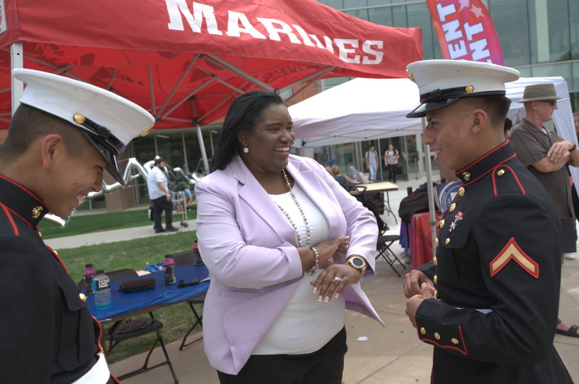 Dr. Proctor laughing with two Marines at outdoor student event