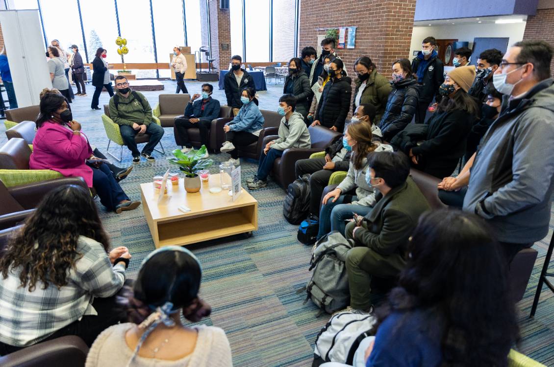 Dr. Proctor sitting with a group of students having a discussion.