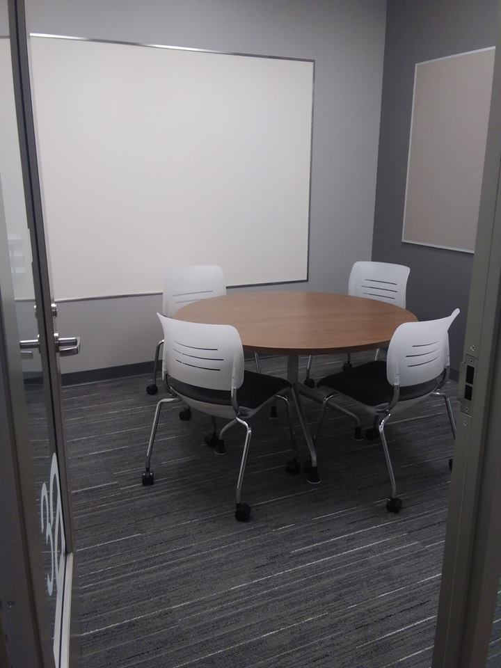 Study room with tables, chairs, and whiteboard