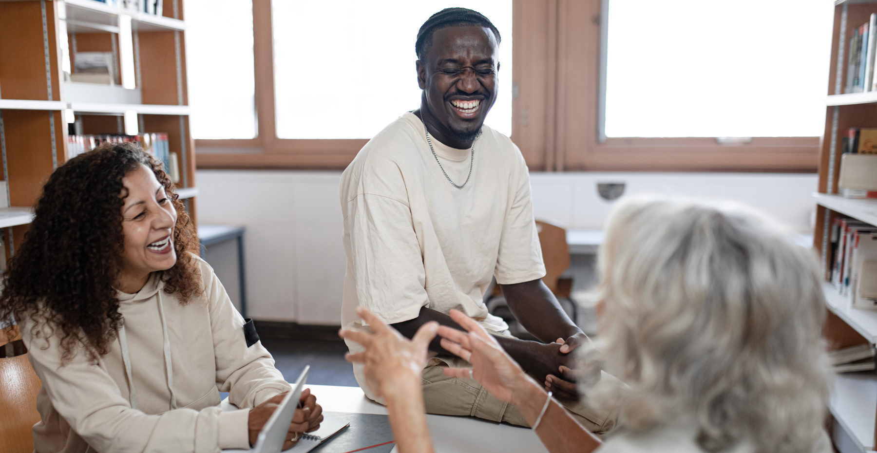 students sitting in library laughing and smiling