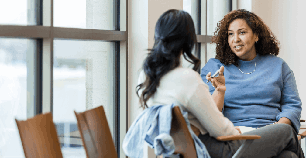 Psychologist talking to a woman by a window