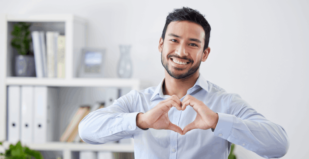Smiling man making a heart shape with hands