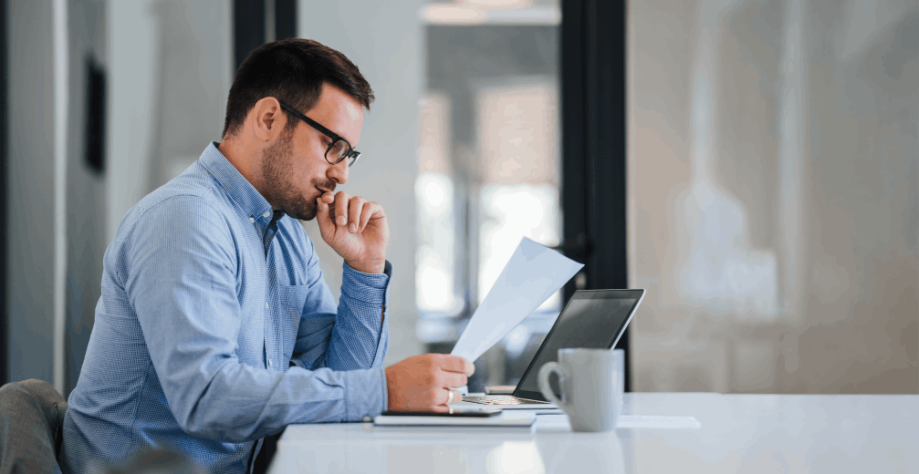 Man reviewing a document at a desk.