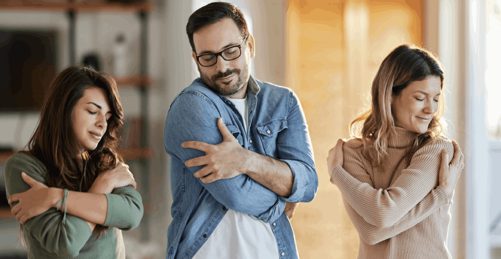 Three people hugging themselves