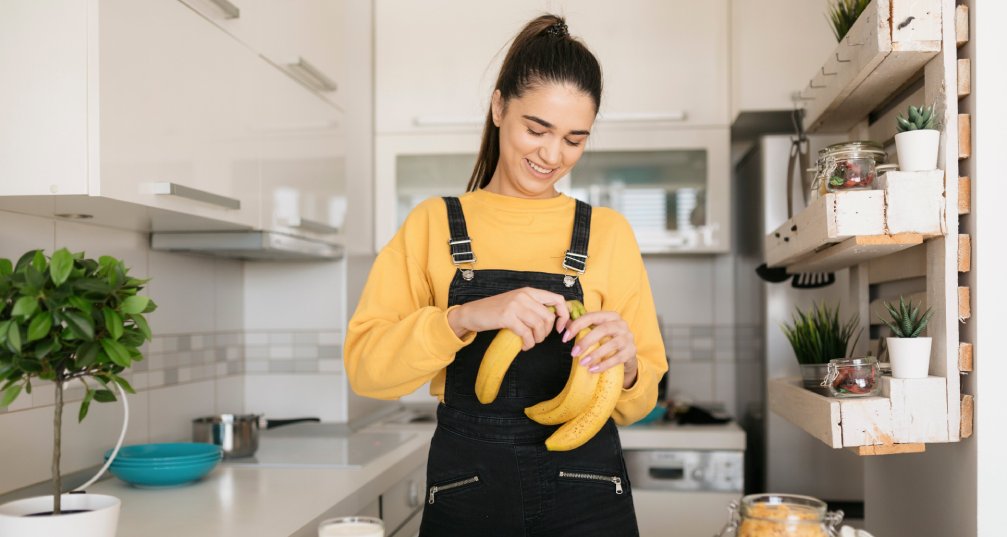 woman standing and preparing bananas in her kitchen