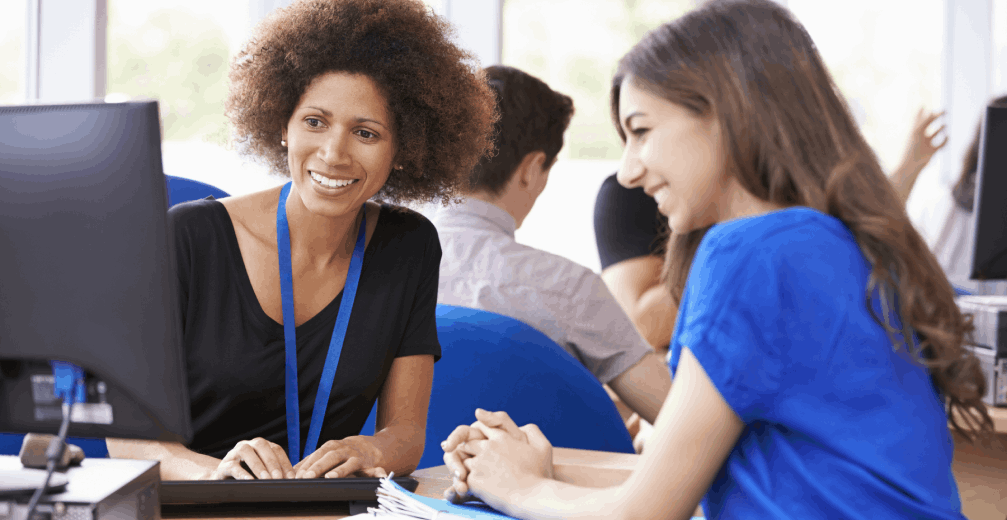 College advisor helping student on a computer.