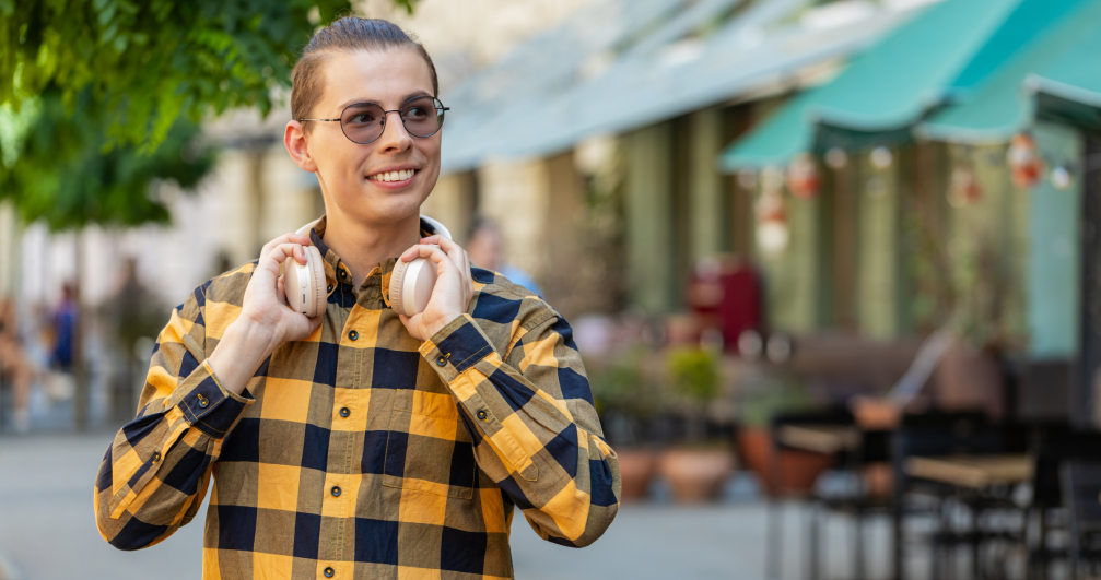 Young person enjoying the sounds of everyday life. a man takes off his headphones to listen to the world around him and put away the distractions