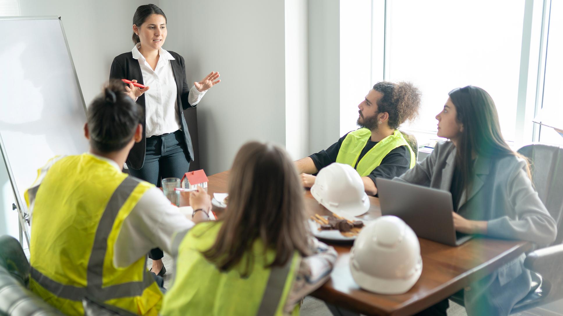 woman in an office teaching a group of construction workers