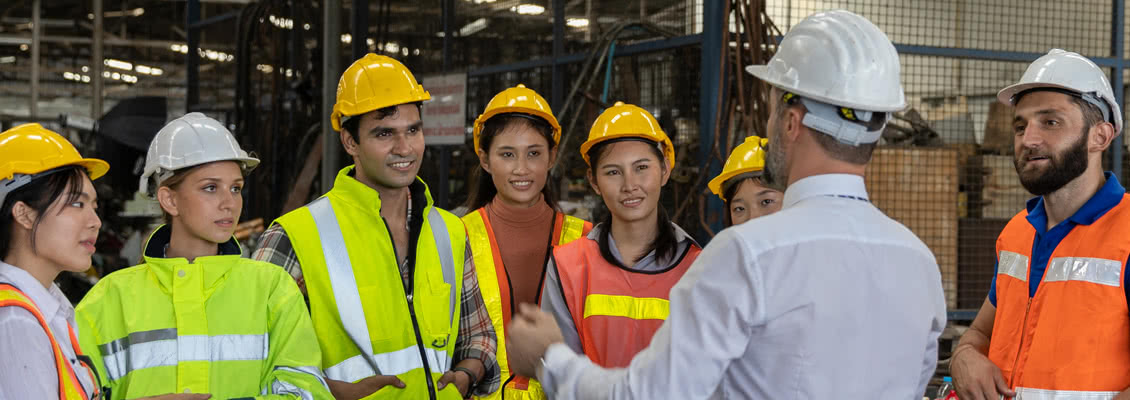 Workers wearing safety hats working on machinery