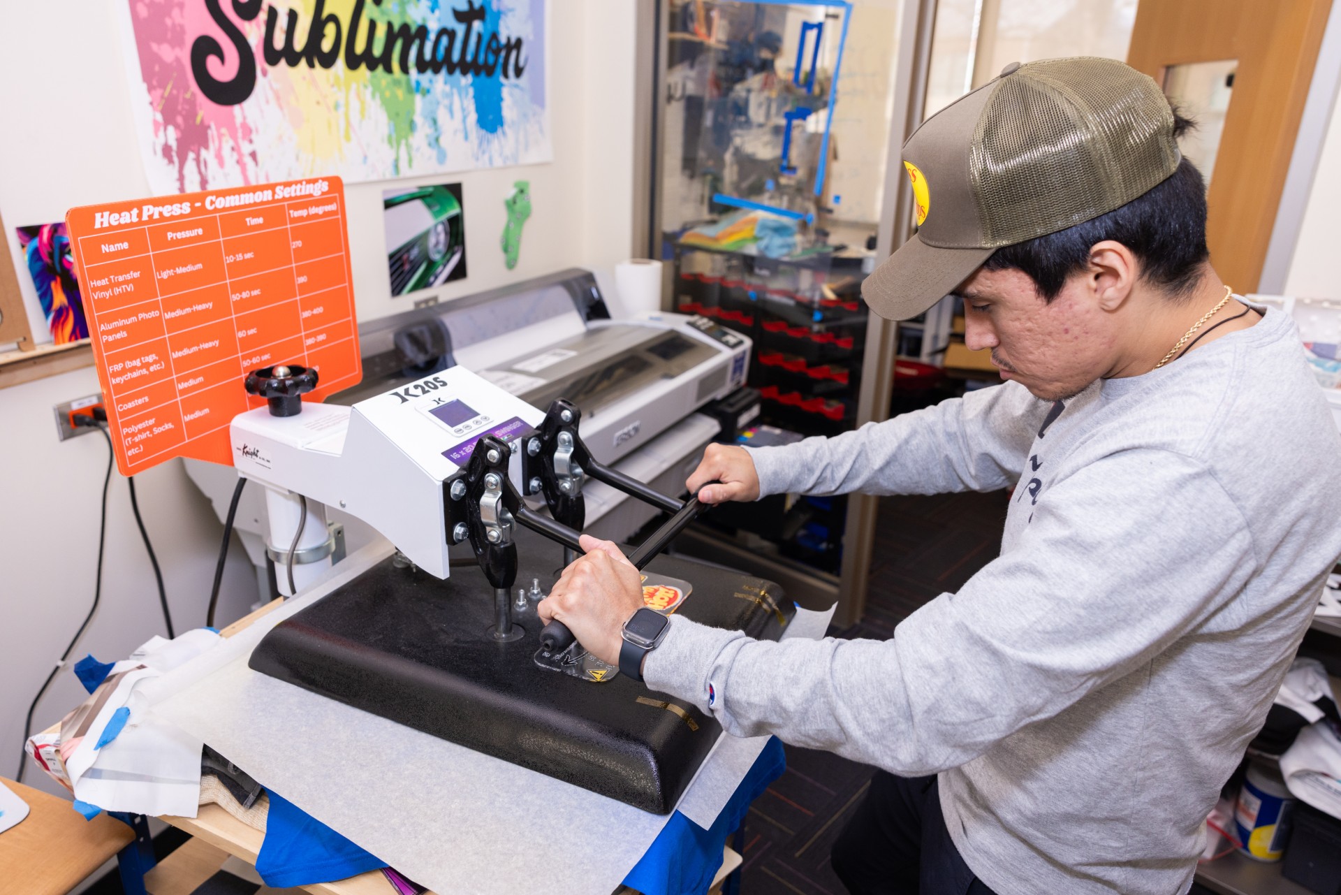 Student working on heating graphic onto t-shirt