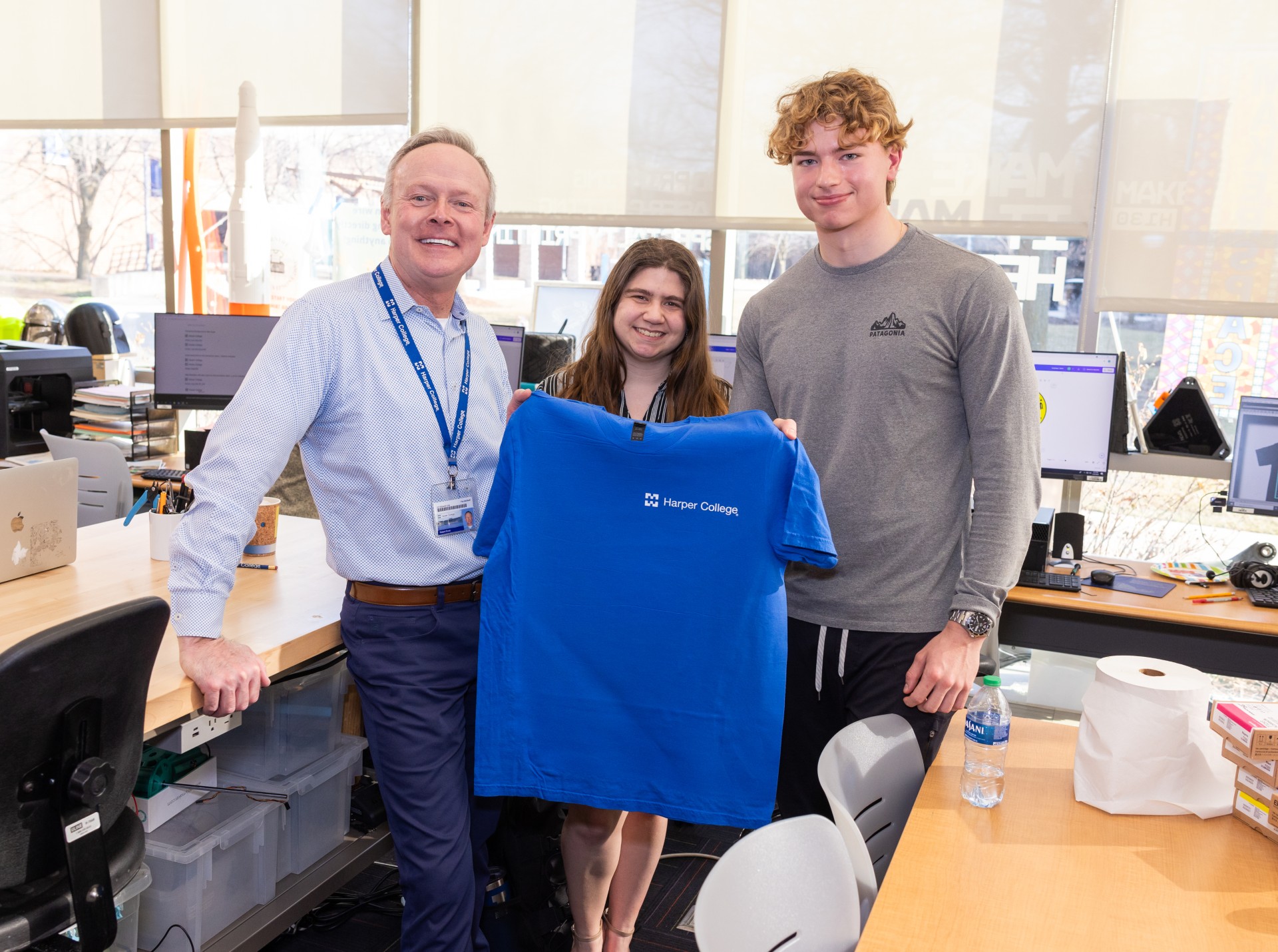 Students and professor holding up t-shirt