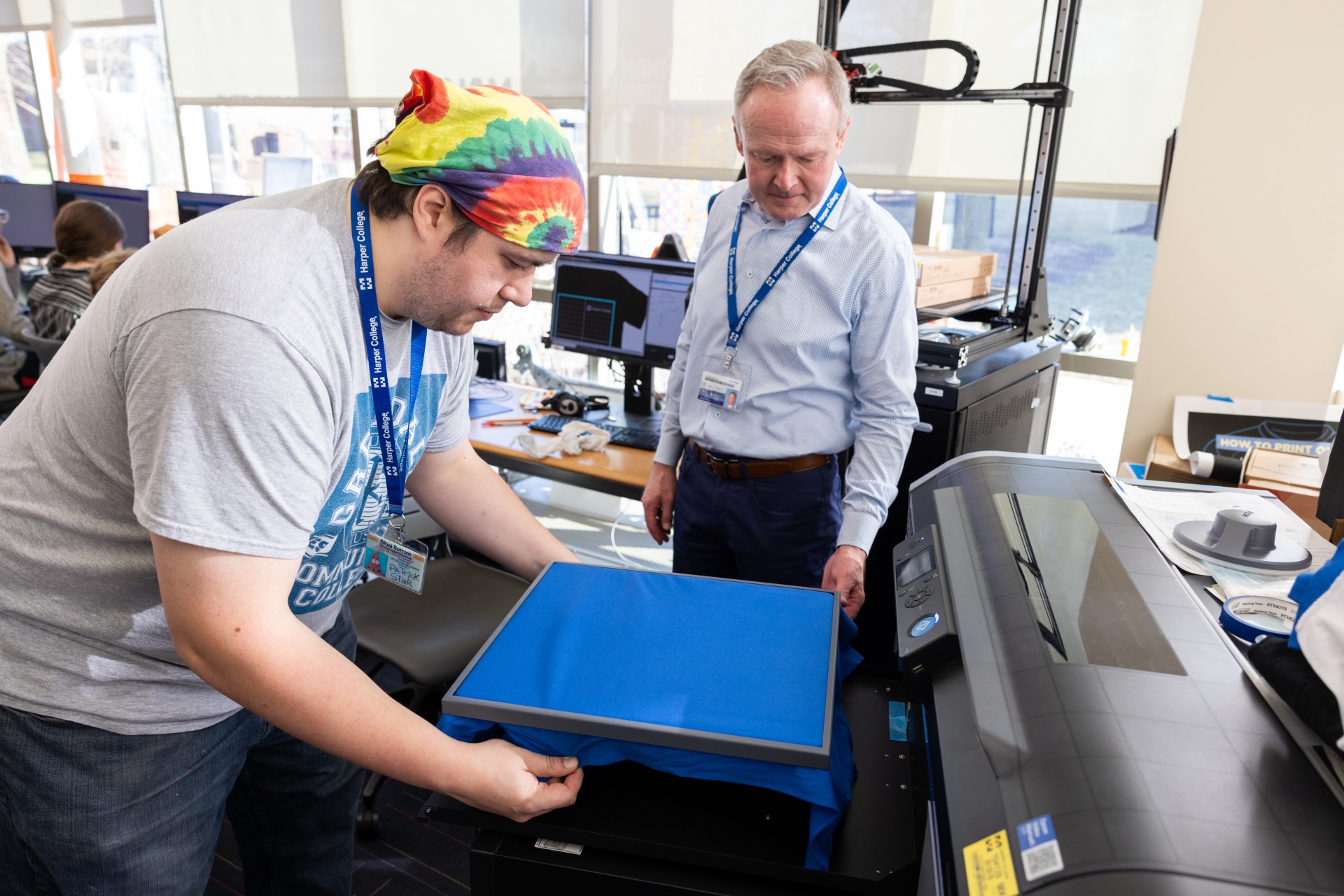Professor showing student how to print graphic onto shirt