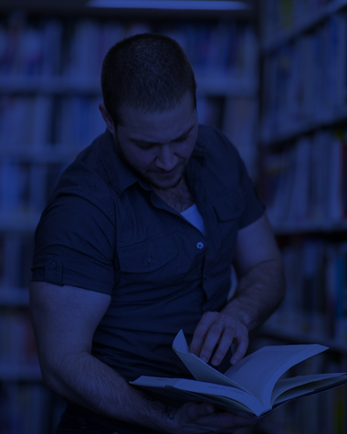 Student in library reading a book