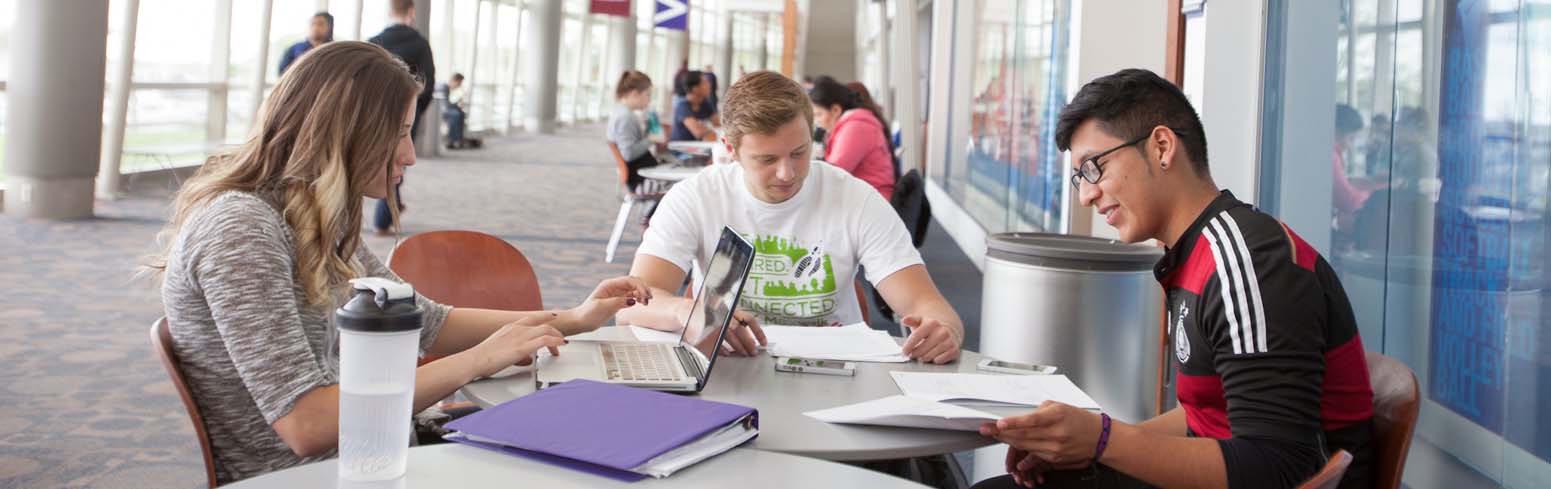 Group of students sitting at a table and doing work