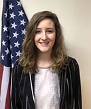 Lydia standing in front of an American flag