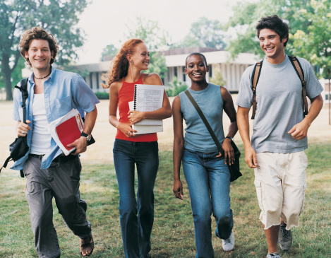 four students walking with books and book bags