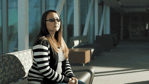 Saly Phom sits on a bench outside of a Harper building