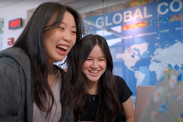 Anna and a friend stand in front of the study abroad office