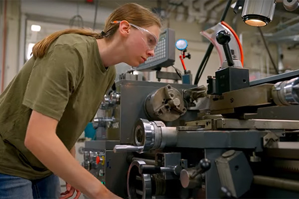 Cassie works on a machine in Harper's manufacturing lab