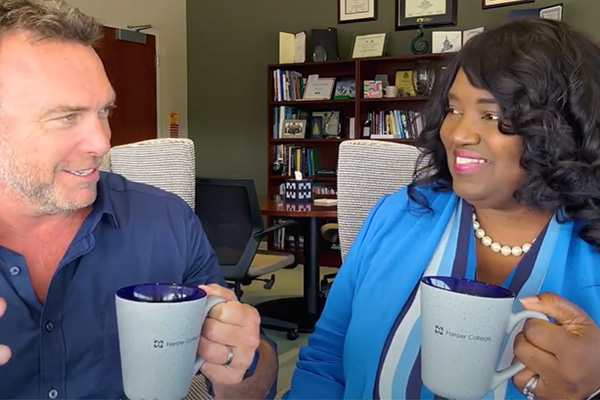 TCT host Alex Boylan and Dr. Avis Proctor hold coffee mugs and talk