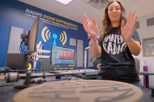 Erika stands at a turntable at Harper's radio station.