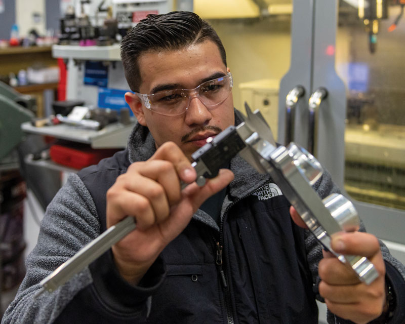 a student uses a tool to adjust a piece of metal