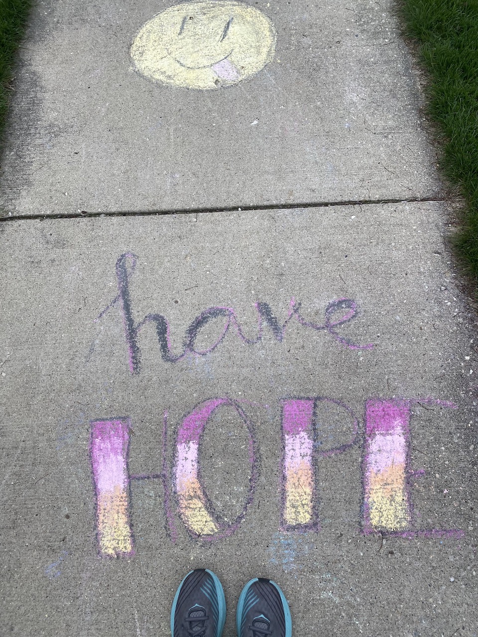 Photo of shoes standing by a chalk drawing with the words, "Have Hope."