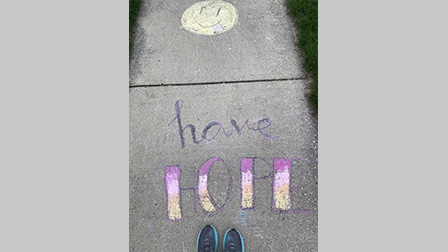 Photo of shoes standing by chalk art that says, 